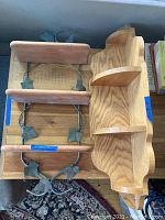 Top-down view showing two wood shelves: a metal-backed shelf with ivy metal frame and a curved wood corner shelf.