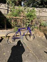 Side view of Schwinn Passage vintage road bike showing blue frame and 26-inch wheels, parked outdoors with shadow of photographer visible.