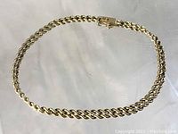 Bracelet laid flat in circular shape showing double strand rope chain and clasp.