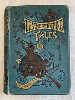 Front cover of the book showing blue background with detailed embossed decorative illustrations and title lettering.