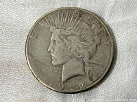 Obverse side of the 1922 Peace Dollar coin showing Lady Liberty's profile with worn details and discoloration.