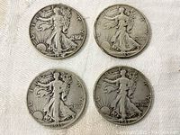 Front (obverse) side of the four Walking Liberty half dollar coins showing Lady Liberty and coin dates.