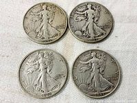 Obverse view of four Walking Liberty half dollar coins dated 1942 and 1943, showing Lady Liberty design.