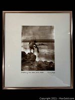 Framed black and white photograph showing a man casting a net on rocky shore with ship in background, titled 'Casting the Net, Hilo, 1898' signed by Anon/Fred Bodin.