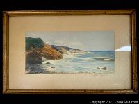 Front of framed artwork showing overall composition of coastal scene with cliffs and ocean waves, signed by John Coggeshall.