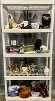 Full view of four shelf rack with all items on shelves, showing the variety of decorative and collectible objects.