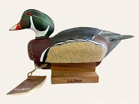 Single wood duck decoy on wooden stand with original LL Bean tag attached, photographed against a plain background with good lighting showing profile and detail.