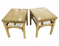 Pair of light tan wicker end tables with rectangular glass tops, showing woven wicker design and lattice side details.