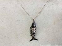 Sterling silver fish pendant on a chain, shown front view on neutral background.