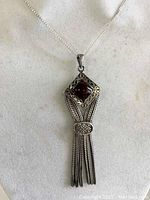 Front view of the Thai sterling silver pendant necklace showing the dark square stone with detailed silver frame and tassels.