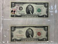 Two US two dollar bills placed in a plastic sleeve: top bill is 1976 series with a red circular stamp dated April 13, 1976. Bottom bill is 1963 series with red seal and serial number.