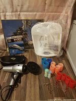 Overview of all items showing hair clippers box, hair dryer, rollers, foot massager, and wall art.