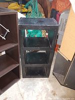 Smaller black lacquer 3-slot cube shelf made from solid wood, showing surface wear.