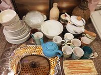 Overview of the collection showing Fire King bakeware bowls, teapots, mugs, plates and other vintage kitchen items.
