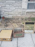 Full view of the three items outdoors: suitcase, 7-Up crate, and mirror.