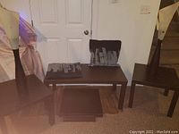 Overview of two wooden designer lamps and IKEA Long black brown coffee and end tables.