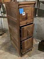 Front and side view of oak filing cabinet with tilt-down drawers and lot sticker