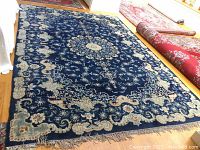 Overall view of rug on hardwood floor showing full pattern and central medallion.