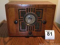 Front view of vintage Monarch tube radio showing wooden cabinet, speaker grille, and central dial.