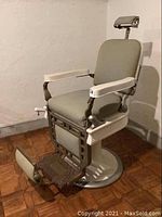 Full front view of barber chair showing seat, back, headrest and base