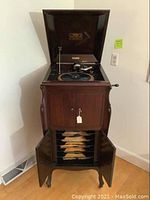 Front view of open cabinet showing turntable on top and album storage below with records