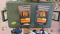 Two boxes of Starter Stikk natural fire starters on green camping cooler box