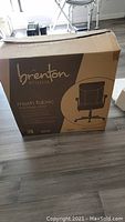 Front side of the original cardboard box showing brand 'Brenton Studio', product type 'mesh fabric mid-back chair' and product image.