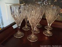 Eight crystal stemware glasses on a tray showing intricate cut patterns