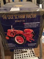 Box front showing image of red The Case SC farm tractor model in 1:12 scale with details about authentic operating features and fully detailed engine.