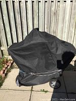 Grill fully covered on wheeled cart