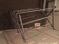 Image of metal collapsible laundry drying rack showing its structure and multiple drying bars.
