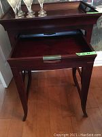 Front view of the larger solid wood nesting table showing tray top and drawer with brass handle.