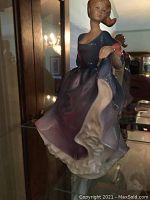 Front angle showing the figurine in a flowing dress with blue, purple, white, and pink details.