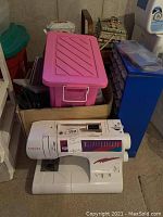 Singer sewing machine in foreground with storage containers behind
