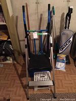 Overall view of items including step stools, push broom, metal dolly, and vacuum in background