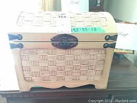 Closed small wicker chest with metal latch and label showing measurements 14.5 x 9.5 x 12 inches