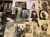 Wide view showing 19 black and white photographic prints laid out on a surface, featuring creative and artistic poses, mostly female subjects with a vintage aesthetic.