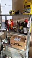 Photo showing a metal shelving unit with multiple car care products including an electric polisher, bottles of tire cleaner, car wax, Prestone antifreeze, and a spray can of foam cleaner.
