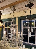 Overall view of both fixtures installed: crystal chandelier center, metal pendant right