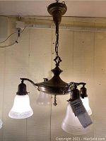 Full view of the hanging fixture with all three shades lit