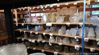 Shelves stocked with dozens of glass lamp shades in clear, frosted and colored finishes