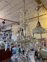 Full view of chandelier showing five arms, bead strands and teardrop pendants