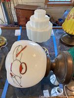 Drop light fixture with white glass globe showing teapot and kitchen themed painted design, mounted on copper fixture base.