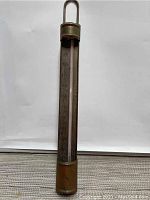 Full view of tall copper candy thermometer with visible temperature scale and aged patina.