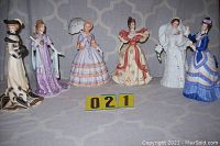 Overview of six Lenox lady figurines in various period dresses lined up side by side