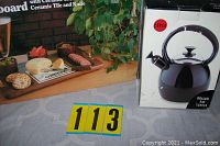 Photo of boxed Copco Camden tea kettle alongside Lucas cheeseboard image on packaging.