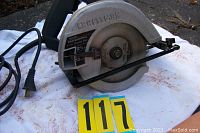 Craftsman 7 1/4 inch circular saw on a white surface with power cord visible, showing the blade guard and brand name.