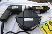 Photo of Duo-Fast drywall screwdriver showing entire tool with cord and black circular screw magazine attachment.