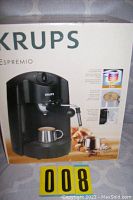 Box packaging of Krups Expremio FNP111 espresso machine showing front with images and branding.