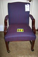 Front view of chair showing seat, backrest, armrests, and wood frame with wheels on front legs